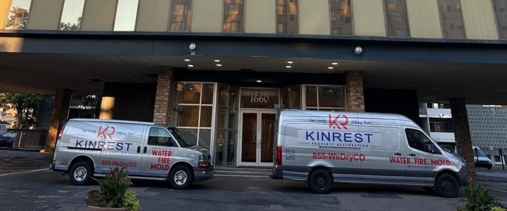 fleet of Kinrest Property Restoration of Denver service trucks in front of building in Denver CO.